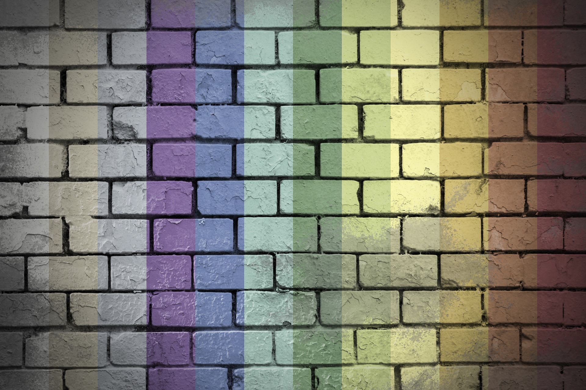Arte com muto de tijolos pintado com faixas nas cores do arco-íris.