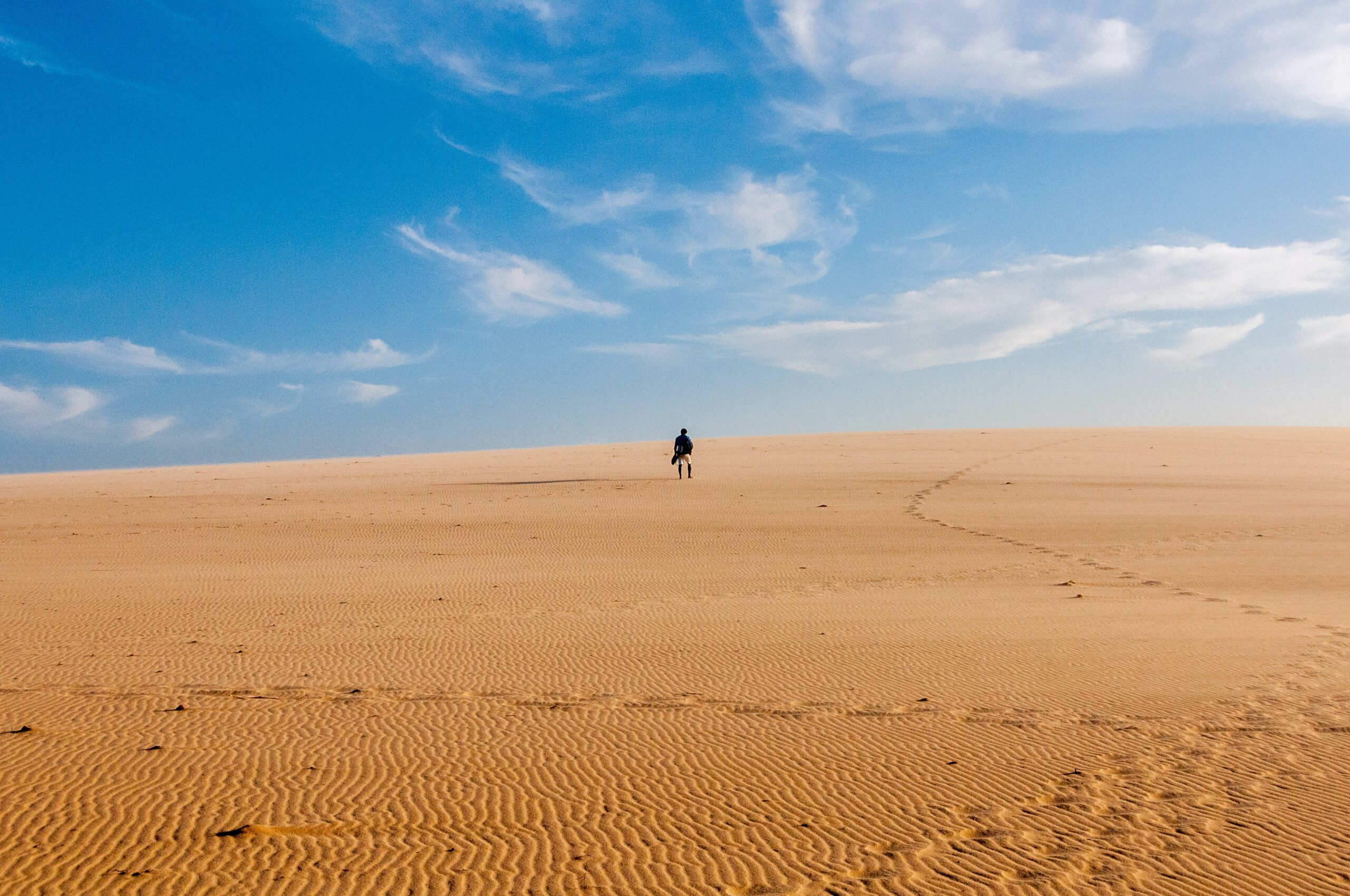 Homem caminha no deserto.