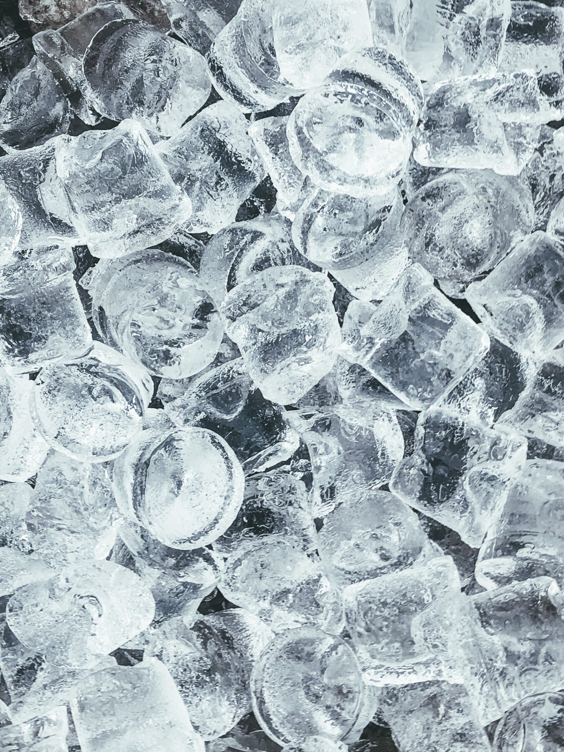 Fotografia de pedras de gelo sobre um fundo escuro.